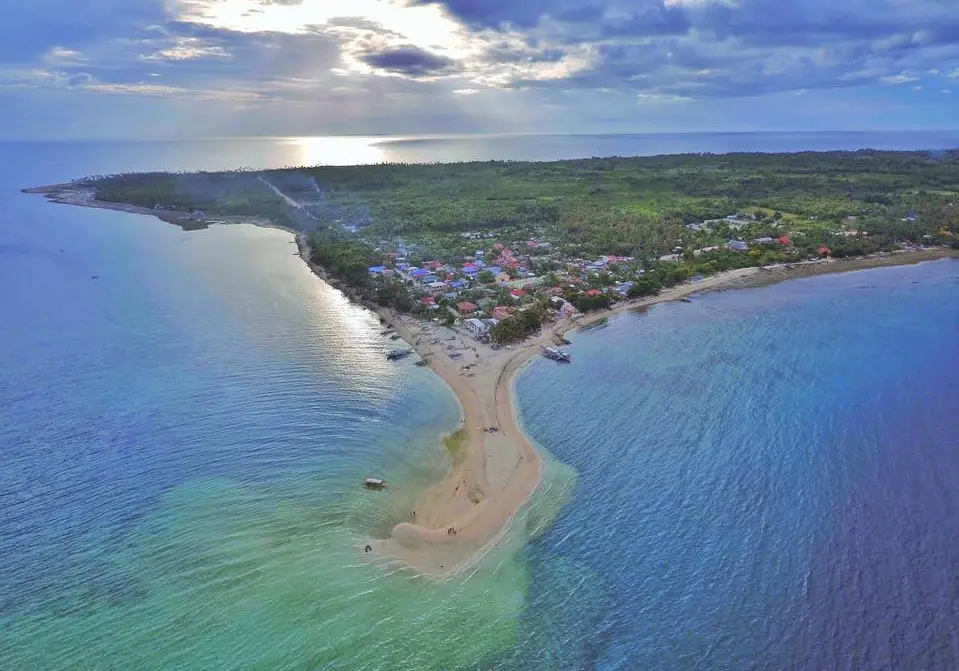 Aerial view of Higatangan Island, featuring white sandy beaches, turquoise waters, and lush greenery.