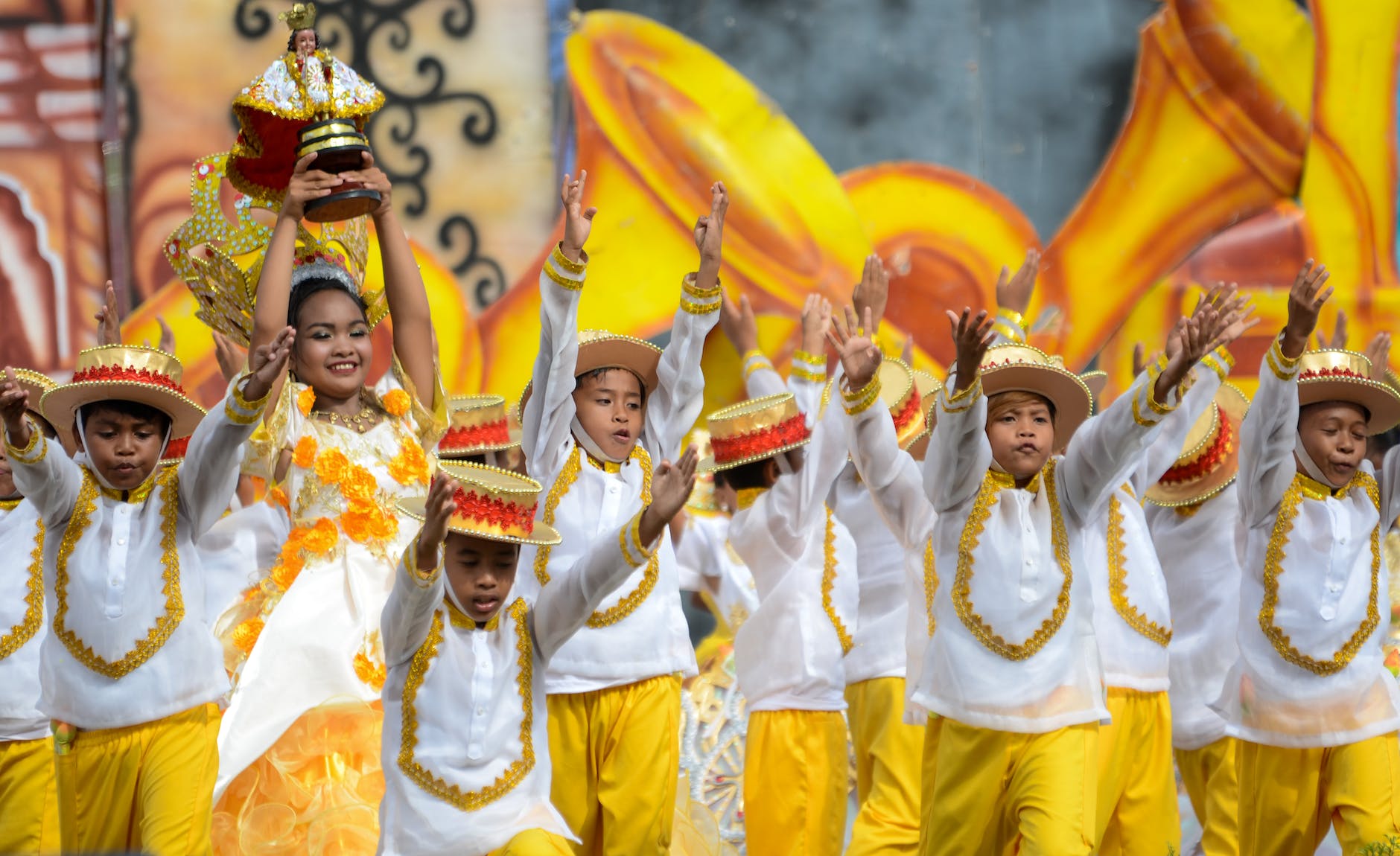 A joyful group of children in colorful costumes dancing during the Sinulog Festival in Cebu City, Philippines.