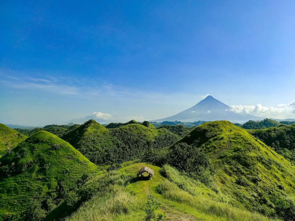 A scenic view of Quitinday Hills and Nature Park in Albay, showcasing lush green hills and a peaceful atmosphere