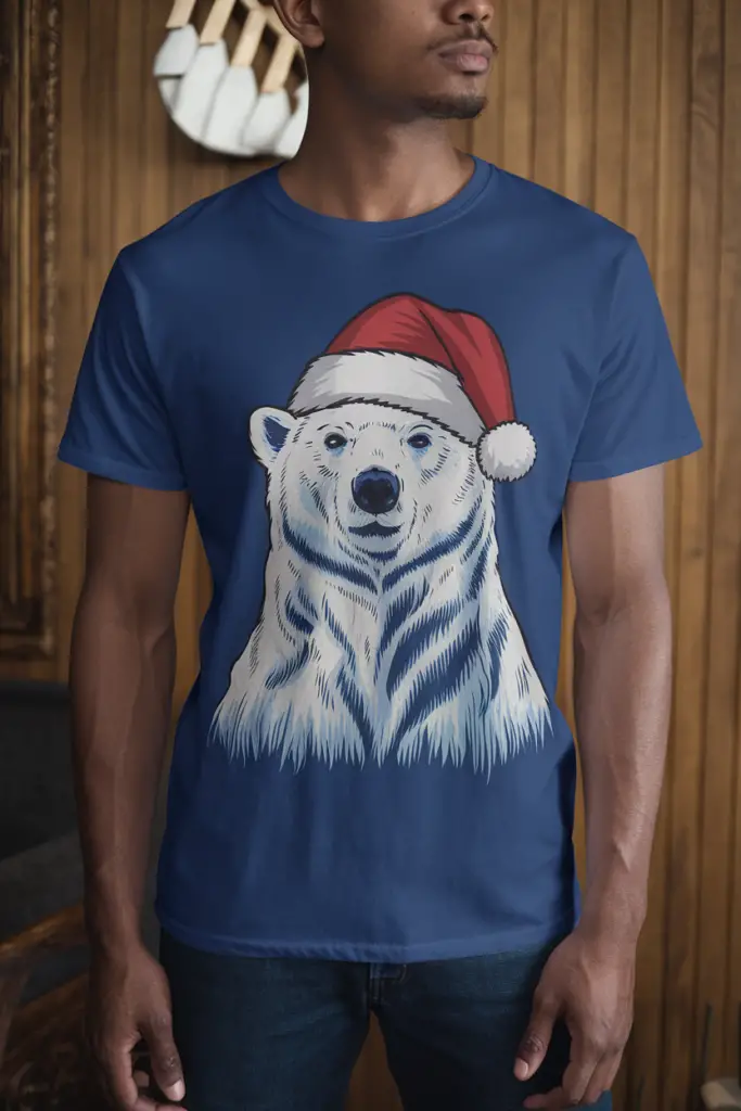 A photo of a random model wearing a unisex t-shirt with a polar bear in a Santa hat design. The t-shirt is visible and worn well on the model, who is standing in a room with a wooden panel wall.